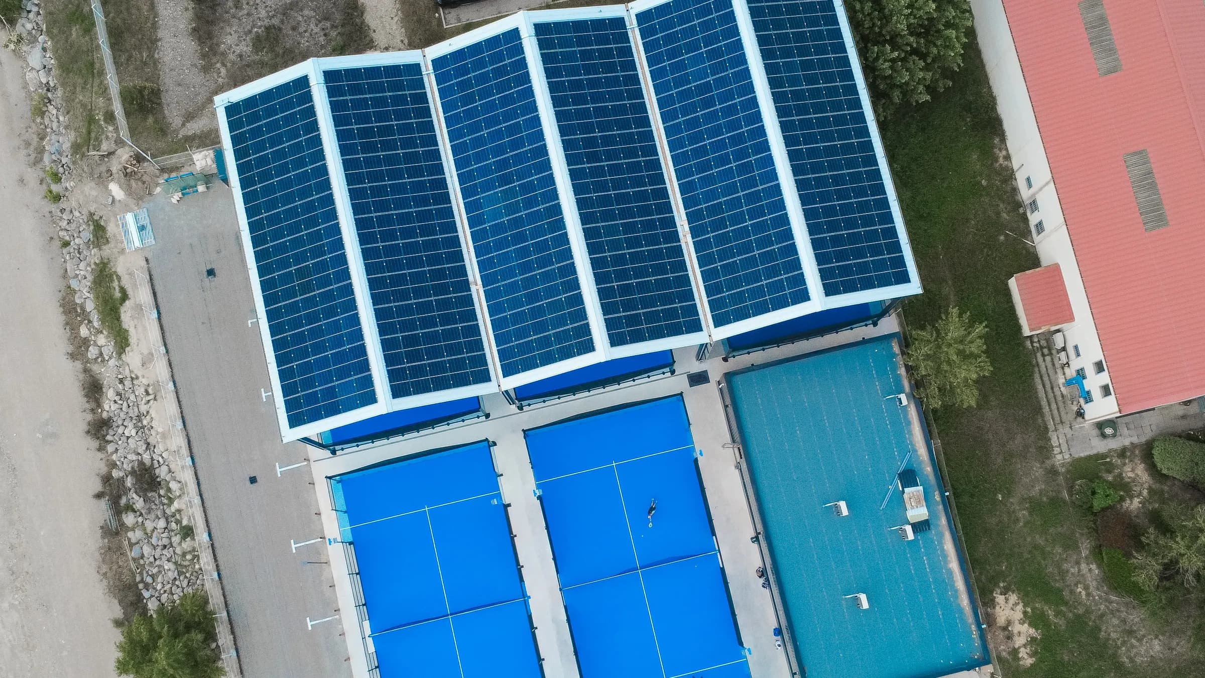 Padel courts from directly above, a solar roof over part of the complex